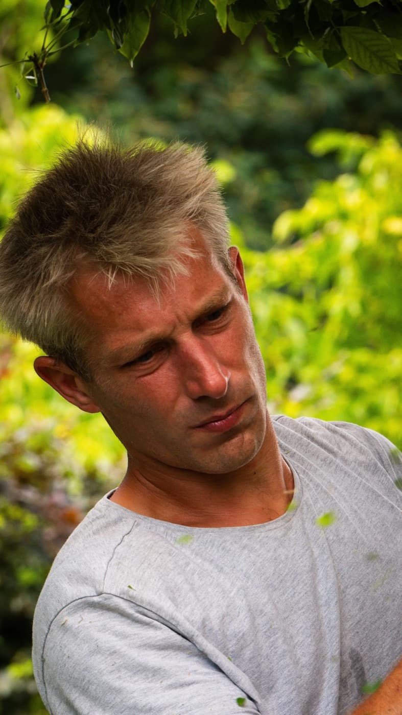 Portrait du paysagiste sur son chantier, sous les feuillages